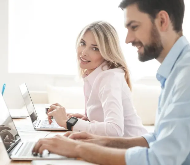 smiling lady with man on laptops